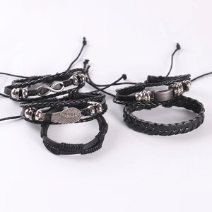Detail of vintage punk leather bracelets with infinity symbol and angel wing charms