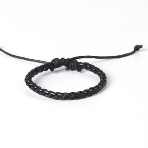 Détail du bracelet tressé noir fait main montrant la texture du cordon et le nœud coulissant