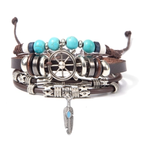 Dettaglio del bracciale multistrato in pelle con perline turchesi e ciondolo a timone