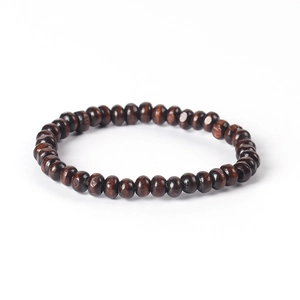 Détail macro du bracelet en perles de bois élastique avec grain naturel brun foncé et poli