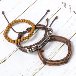 Three-piece hope leather bracelet set with wooden beads on rustic background