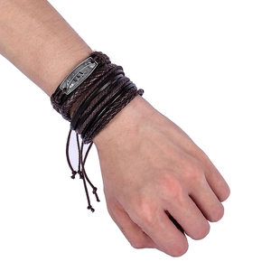 Close-up of multilayer leather bracelet set with retro silver feather charm on wrist