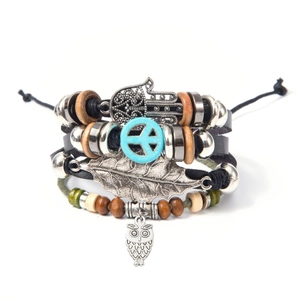 Dettaglio del bracciale multistrato in pelle boho con ciondoli gufo e hamsa