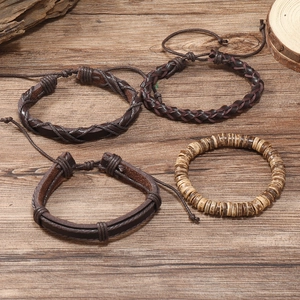 Detail of 4-piece vintage leather and wooden bead braided bracelet set on wood background
