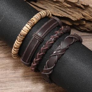 Set of four men's vintage leather and wooden bead woven bracelets on a wooden display stand