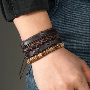 Men's multilayered leather and wood bead woven bracelet set on denim background