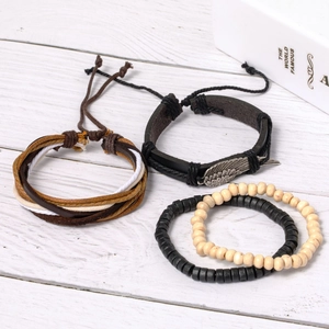 Close-up of three-piece vintage leather bracelets with feather charm and wood beads