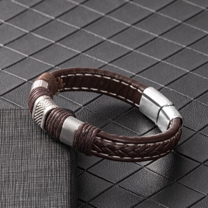 Detail of dark brown braided leather bracelet with silver magnetic clasp and stitching