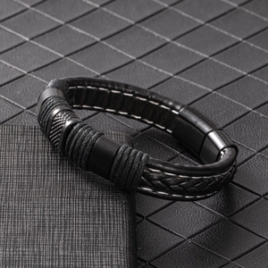 Close-up of black braided leather men's bracelet with magnetic clasp and white stitching