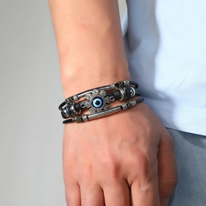 Dettaglio del bracciale multistrato in pelle con occhio blu e decorazioni in metallo argento