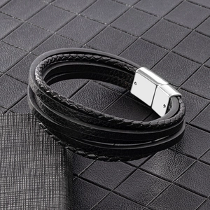 Detail of multi-layer braided leather bracelet with polished magnetic silver clasp