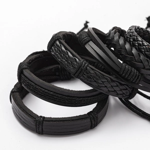 Macro detail of layered black braided leather bracelets with multiple weave textures