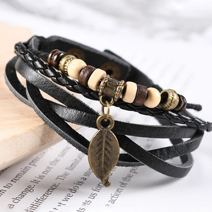 Detailed macro shot of vintage multilayer leather bracelet with a bronze leaf pendant