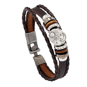 Vintage multi-layer braided leather bracelet with sun, moon, and star charms in brown