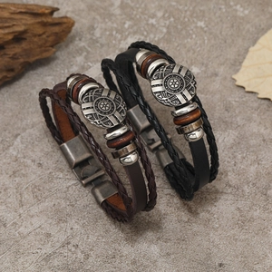 Detailed close-up of dark brown and black multi-layer braided leather bracelets with beads