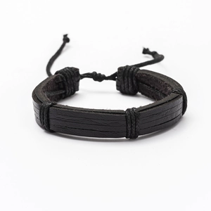 Detail of multi-layered black braided leather bracelet with adjustable cord closure