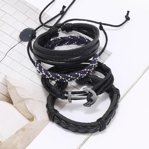 Detail of multi-layer braided leather bracelets with a vintage silver anchor pendant charm