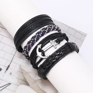 Detail of multi-layer leather bracelets with a vintage silver metal anchor pendant
