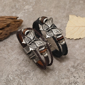 Détail de bracelets en cuir tressé multicouches avec papillon argenté et perles bois