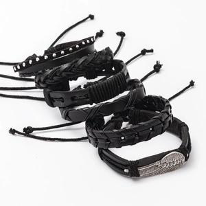 Detail of 5-piece men's black leather bracelet set with wing charm and braided texture