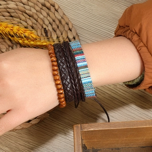 Détail de bracelets bohèmes multicouches avec cuir, perles en bois et tissu tissé