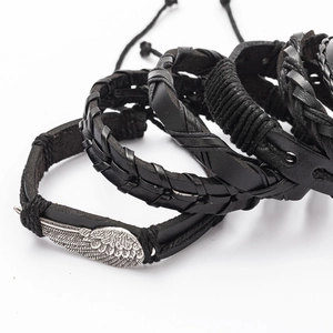 Detail view of black woven leather bracelets with silver wing charm and adjustable cords