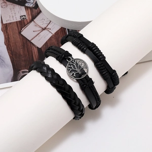 Close-up of black braided leather bracelets with silver Tree of Life charm on a display