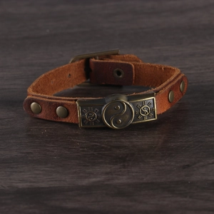 Vintage brown leather bracelet with bronze Yin Yang and Bagua symbols in a closed loop