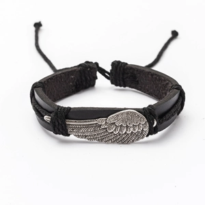 Detail view of black leather braided bracelet featuring a silver metal wing charm
