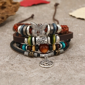 Handgefertigtes Lederarmband-Set mit Schmetterling und Lebensbaum auf Stein-Hintergrund