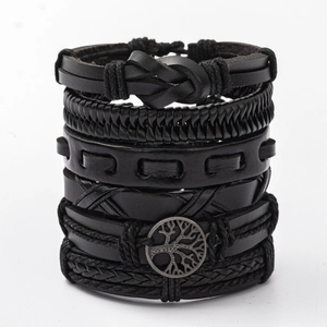 Detail of multi-layered black leather bracelets with braided ropes and tree of life charm