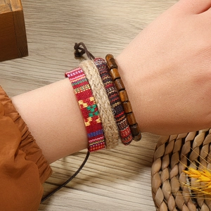 Détail de quatre bracelets bohèmes faits main avec perles en bois et motifs ethniques