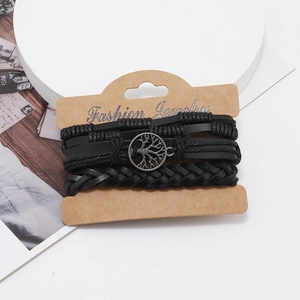 Detail view of multi-layered black braided leather bracelet with Tree of Life charm