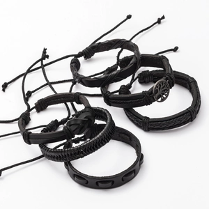 Detail view of multi-layer black leather bracelets with Tree of Life charm and metal studs