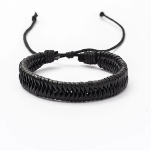 Detail view of black double-layered braided leather bracelet with adjustable drawcord clasp