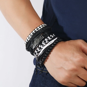 Detailed shot of multi-layer men's braided bracelets with Tai Chi symbol on white background