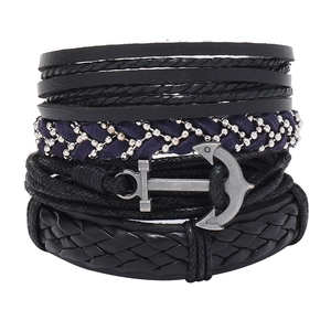 Détail d'un bracelet bohème multicouche avec cordons en cuir, tressage et un pendentif ancre