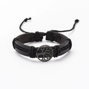 Detail of hand-woven black leather bracelet featuring a silver Tree of Life metal charm