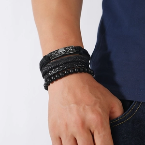 Close-up of men's multi-layer braided leather bracelet set with retro skull alloy charm