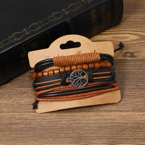 Detail of multi-layer leather bracelet set with tree of life charm on wood background