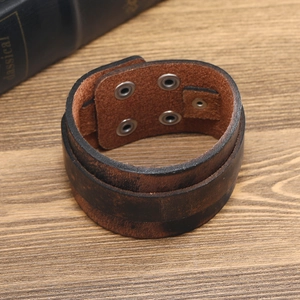 Vue détaillée d'un bracelet en cuir marron vintage avec double rangée de boutons pressions