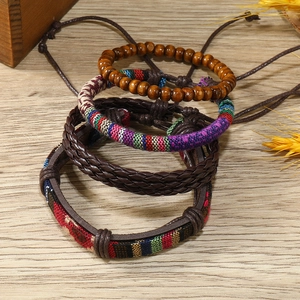 Détail de quatre bracelets bohèmes perlés et tressés sur un fond en bois rustique