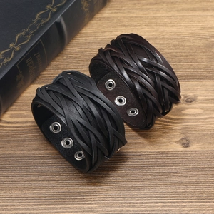Vintage Punk Herren-Lederarmbänder geflochten in Schwarz und Braun auf Holzhintergrund