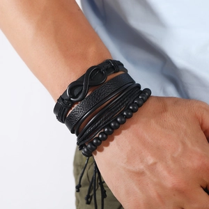 Macro detail of men's black multi-layer braided leather bracelet with infinity symbol