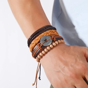 Macro shot of multi-layer men's braided leather bracelet with wood beads and metal charms