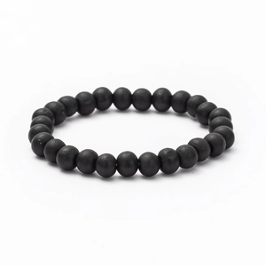 Macro view of matte black beaded bracelet featuring natural stones and elastic band