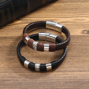 Detailansicht geflochtener Lederarmbänder mit Magnetverschlüssen auf Holzoberfläche