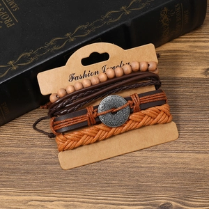 Detail of multilayer woven leather bracelet with wooden beads and sun totem charm