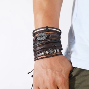 Détail de bracelets multicouches en cuir faits main avec breloques ethniques en métal