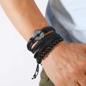 Detail of multi-layer men's leather bracelet set with antique silver geometric charms